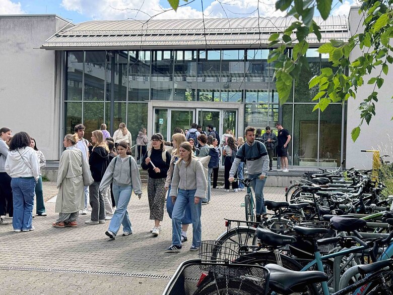 zu sehen sind Studierende vor dem Hörsaalgebäude