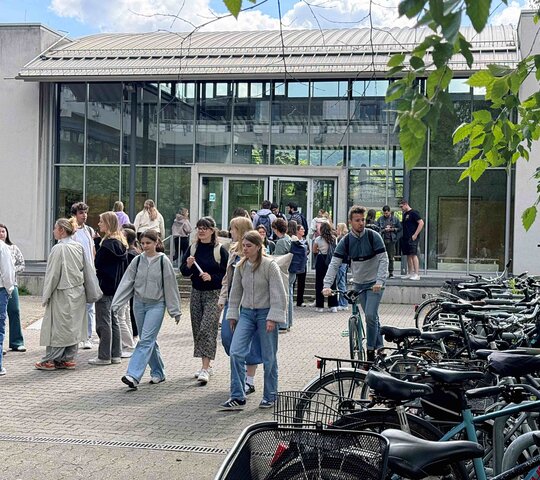 zu sehen sind Studierende vor dem Hörsaalgebäude