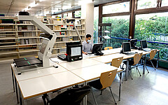 Das Foto zeigt leere Tische in der Bibliothek.