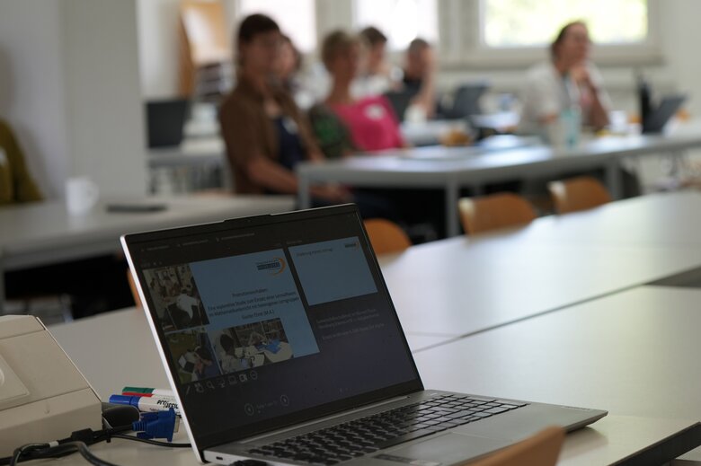 Zu sehen ist ein aufgeklappter Laptop während eines Forschungskolloquium. 