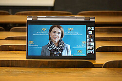 Das Foto zeigt Convertible Notebook in einem Hörsaal stehend. Auf dem Bildschirm ist Petra Olschowski zu sehen. 