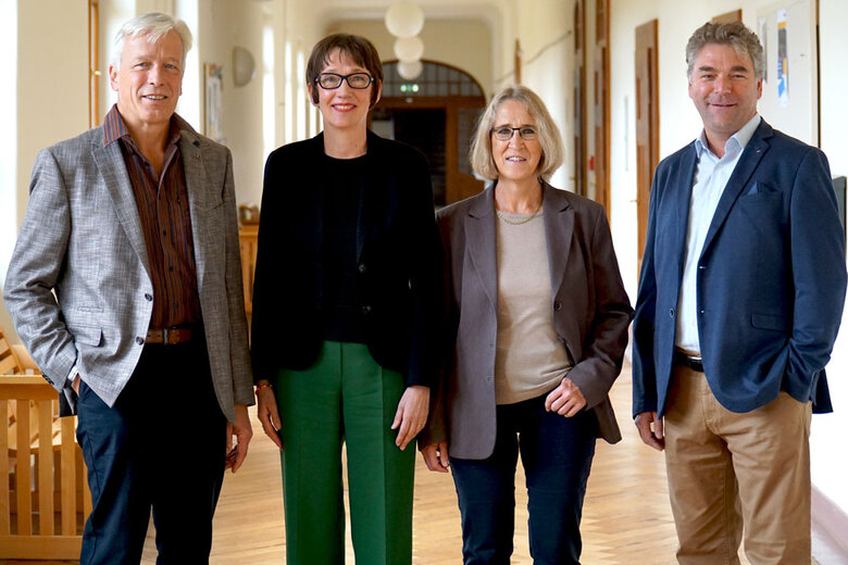 Karl-Heinz Dammer, Karin Vach, Stephanie Wiese-Heß und Alexaner Siegmund stehen im Flur des Altbaus. Sie lächeln freundlich in die Kamera.