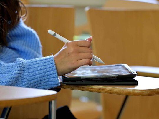 Studentin schreibt auf Tablet