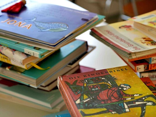 Bücher liegen gestapelt auf dem Tisch.