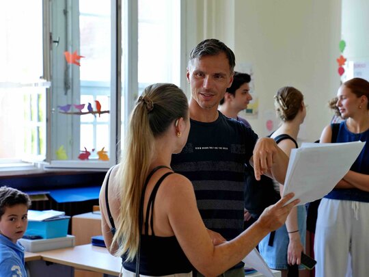 Ein Lehrer erklärt einer Schülerin etwas.