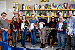 Das Bild zeigt ein Gruppenfoto von Studierenden mit ihrer Hausarbeit in der Hand.