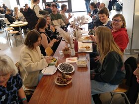 Mitarbeitende und Studierende der PH Heidelberg sitzen am PHeelGood-Tisch und unterhalten sich.