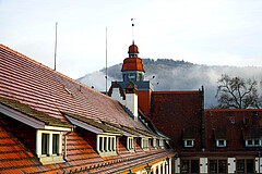 Das Symbolbild zeigt das Dach des Altbau der Hochschule. Da hinter sieht man die Bergstraße im Nebel. Copyright: PH Heidelberg