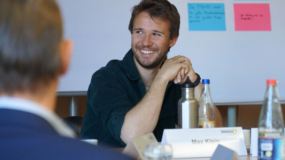 Max Klein während eines Workshops. Er lächelt breit.