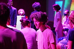 Das Foto zeigt eine Szene des Theaters im violetten Licht.