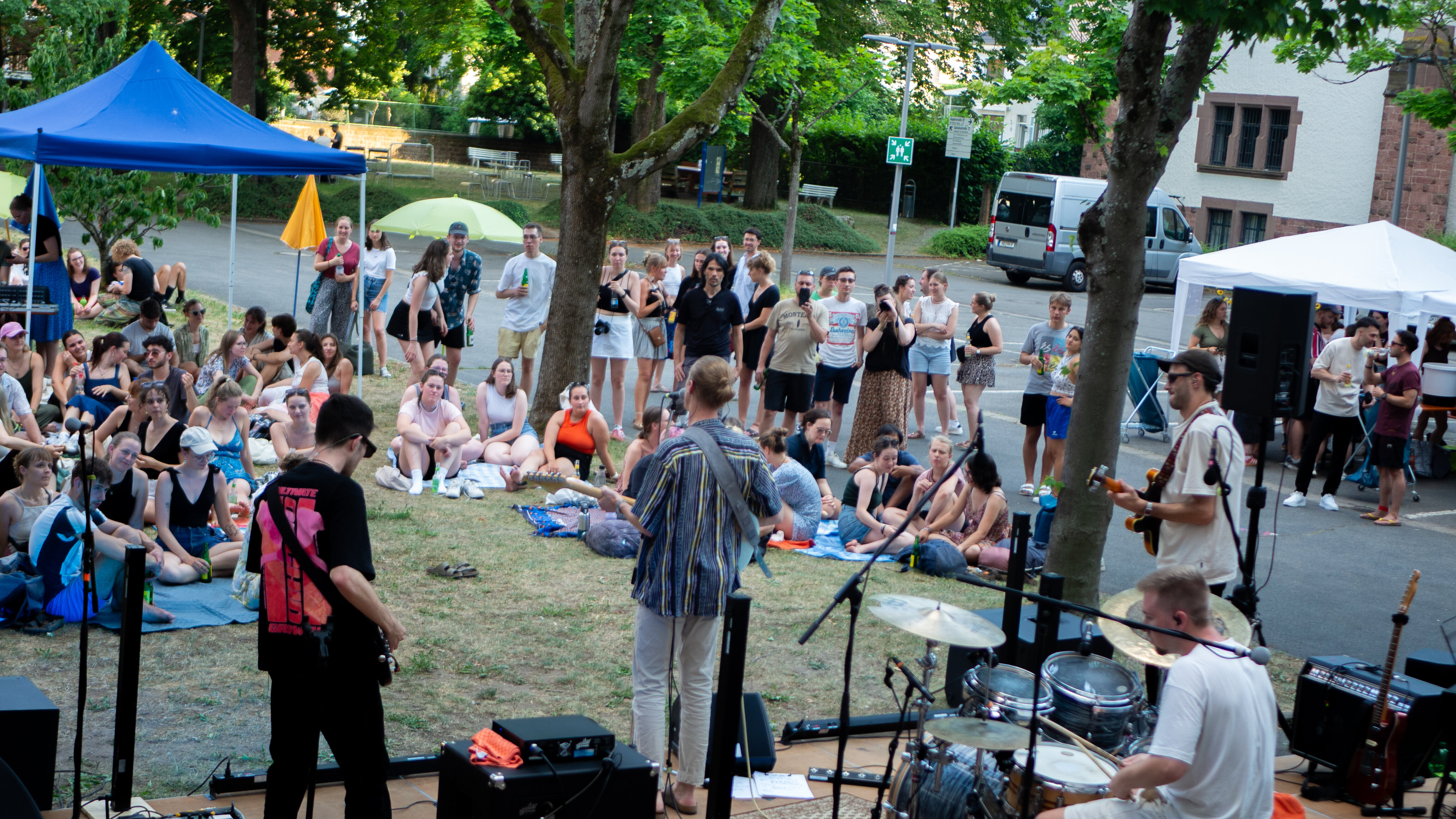 Studierende sitzen im Innenhof der PH, auf der Bühne spielt eine Band aus 4 Musikern.