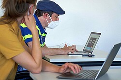 Das Bild zeigt zwei Menschen vor jeweils einem Laptop. Copyright Pädagogische Hochschule Heidelberg