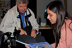 Das Foto zeigt einen Lehrenden und eine Studentin am bundesweiten Vorlesetag zum Thema „Auf Reisen“ im Heidelberger Mehrgenerationenhaus.
