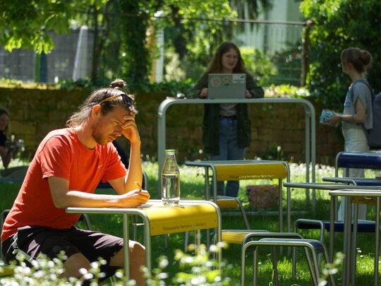 Personen lernen sitzend und stehend im Innenhof der Alten PH.