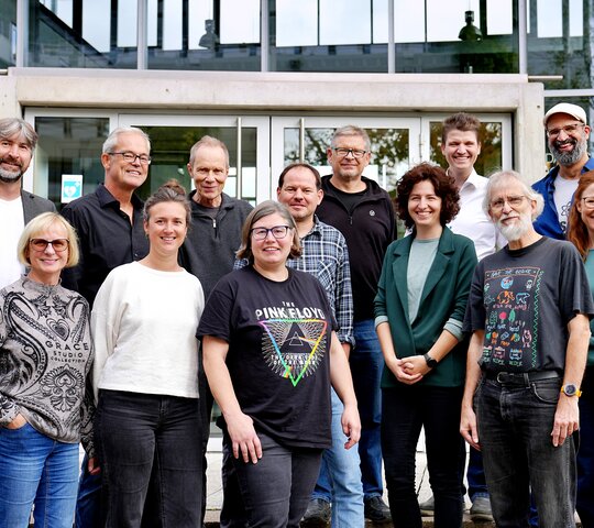 Mitarbeitende des Institut für naturwissenschaftliche und technische Bildung stehen vor dem Hörsaalgebäude.