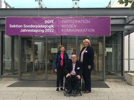 Das Foto zeigt drei Personen einem Gebäude, in dem die Jahrestagung der  Jahrestagung der Sektion Sonderpädagogik der Deutschen Gesellschaft für Erziehungswissenschaft stattgefunden hat..