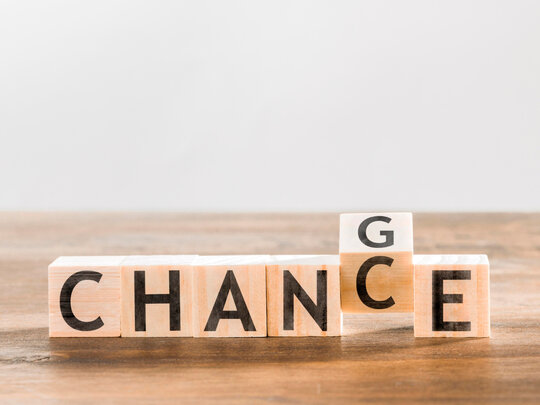 Buchstabenwürfel aus Holz bilden das Wort CHANCE. Das zweite C ist gedreht, sodass auf der angrenzenden Seite ein G zu sehen ist. Botschaft: Change = Chance.