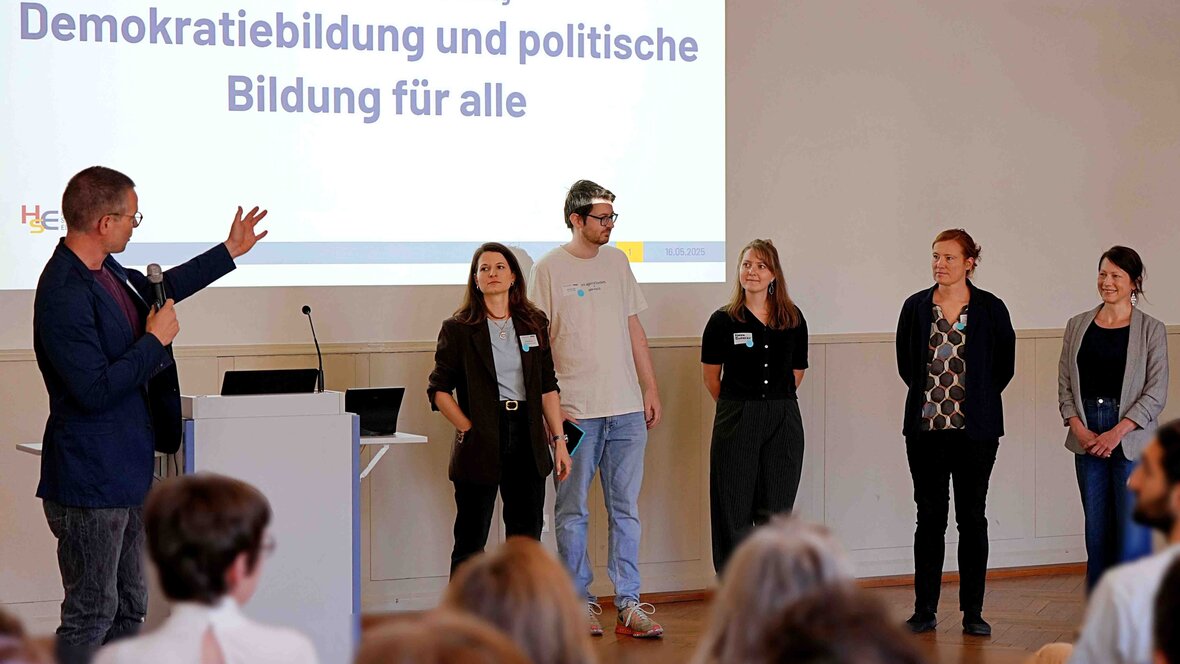 Zu sehen ist eine Präsentation mehrerer Personen. 