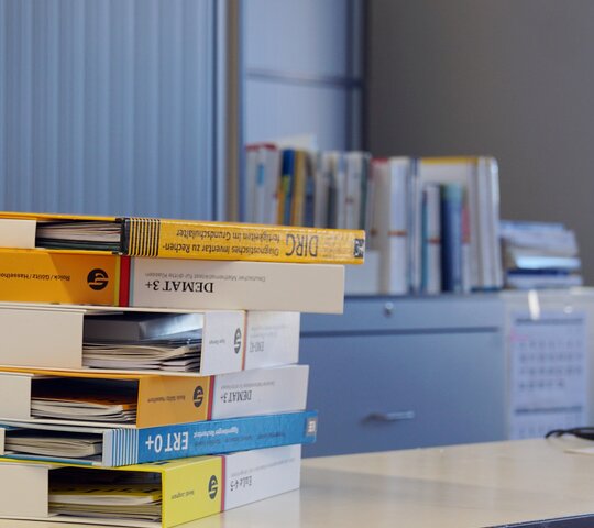 Bücher liegen gestapelt auf einem Tisch.