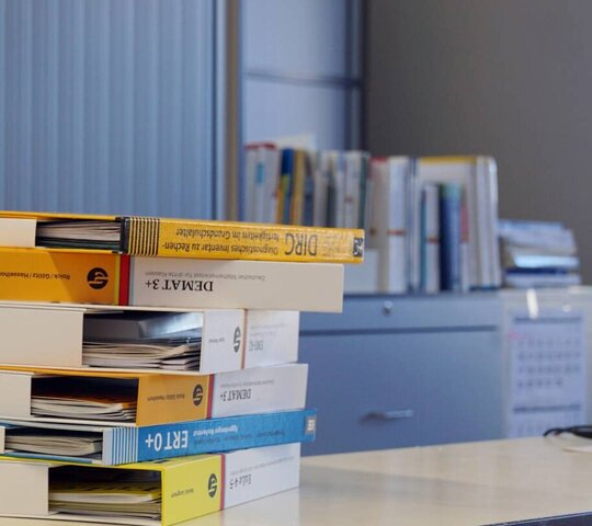 Bücher liegen gestapelt auf einem Tisch.