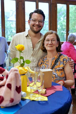 Zu sehen sind zwei Personen beim Sektempfang.