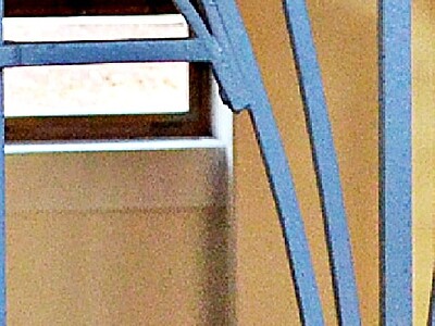 Blaues Geländer vor einem Fenster.