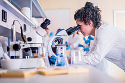 Das Bild zeigt eine Frau in vor einem Mirkoskop in einem Labor. Copyright Pixabay