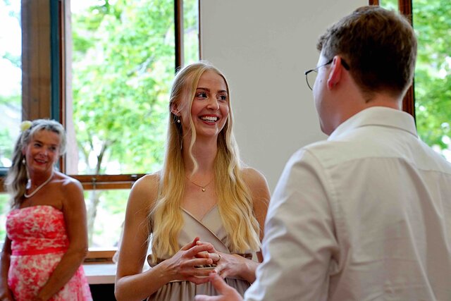 Zu sehen sind sich unterhaltende Menschen von vorne und hinten beim Sektempfang.