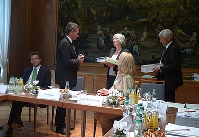 Die Übergabe eines Ringordners mit Materialien zur Verbraucherbildung an Minister Oettinger durch Prof. Dr. Barbara Methfessel.