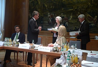 Die Übergabe eines Ringordners mit Materialien zur Verbraucherbildung an Minister Oettinger durch Prof. Dr. Barbara Methfessel.