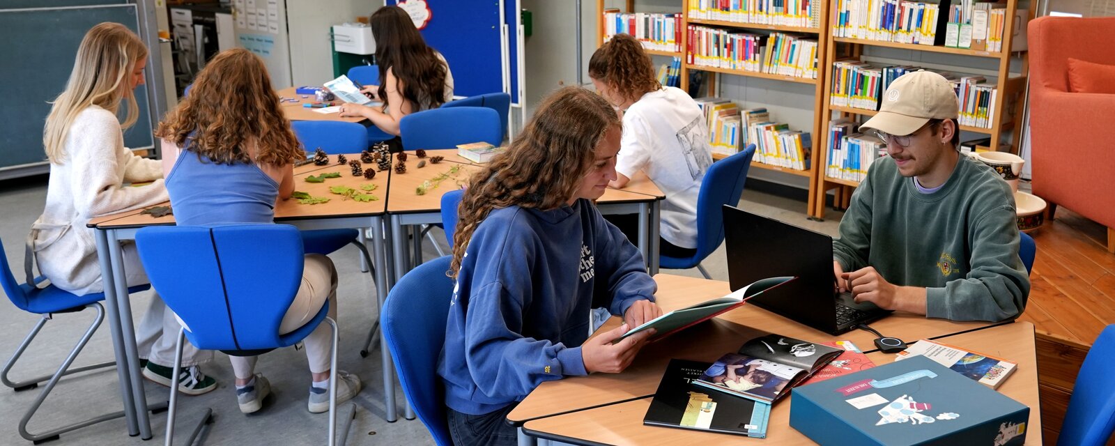 Studierende des Faches Sachunterricht sitzen an verschiedenen Tischen in der Didaktischen Werkstatt Sachunterricht und probieren Lehrmaterialien aus.
