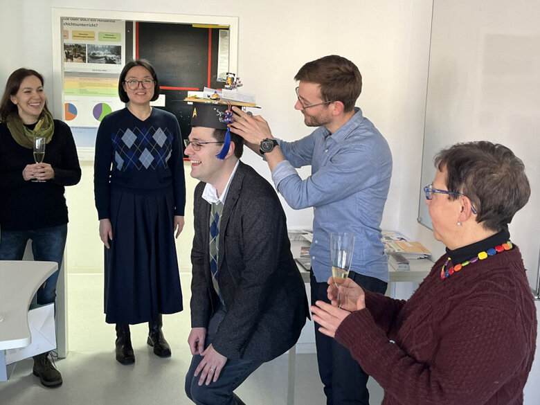 Foto der feierlichen Überreichung der akademischen Mütze an Andreas Spiziali durch einen Kollegen
