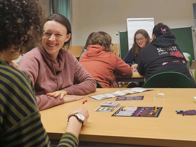 Menschen spielen gemeinsam Brettspiele