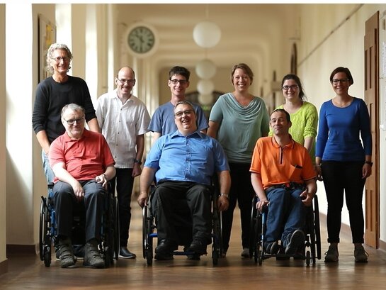 Das Bild zeigt die Bildungsfachkräfte der AW-ZIB. Im Vordergrund sind drei im Rollstuhl, dahinter stehen sechs weitere Personen.