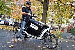 Das Foto zeigt das Elektro-Lastenfahrrad der Poststelle.