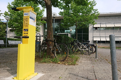 Das Bild zeigt die neue Fahrradreparaturstation vor der Sporthalle.