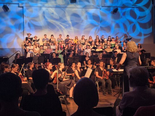 Zu sehen sind der Hochschulchor und das Orchester der Pädagogischen Hochschule Heidelberg bei einem gemeinsamen Auftritt. 