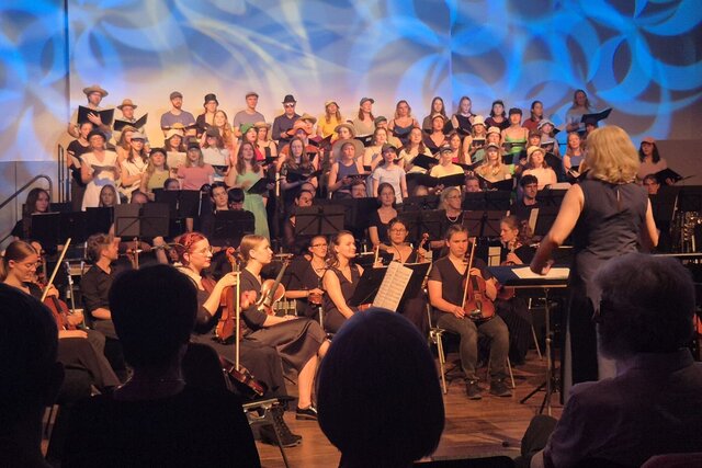 Zu sehen sind der Hochschulchor und das Orchester der Pädagogischen Hochschule Heidelberg bei einem gemeinsamen Auftritt. 