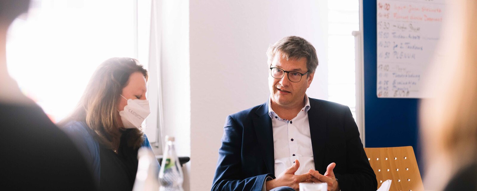 Perrson im Gespräch an einem Konferenztisch