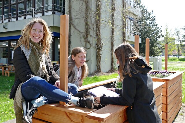 Zu sehen sind 3 Menschen vor einem Hochbeet bei der Seminarwiese am Neubau der Pädagogischen Hochschule Heidelberg, welche PHeelGood mitgestaltet hat.