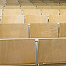 Das Foto zeigt leere Stuhlreihen eines Hörsaals.