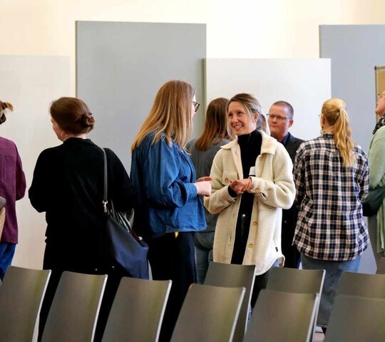 Gruppe von Frauen steht zusammen und ist im Gespräch.