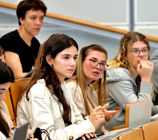 Studierende sitzen im Hörsaal und schauen nach vorne.