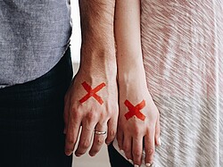 Zwei Hände mit jeweils einem roten Kreuz.