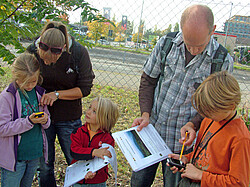 Zwei Erwachsenen und drei Kinder beim Geocaching Day der GIS-Station.