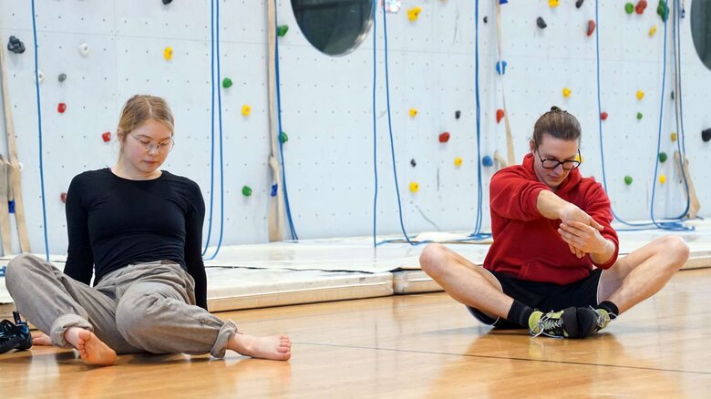 Zu sehen sind zwei Studierende nach dem Klettern. 