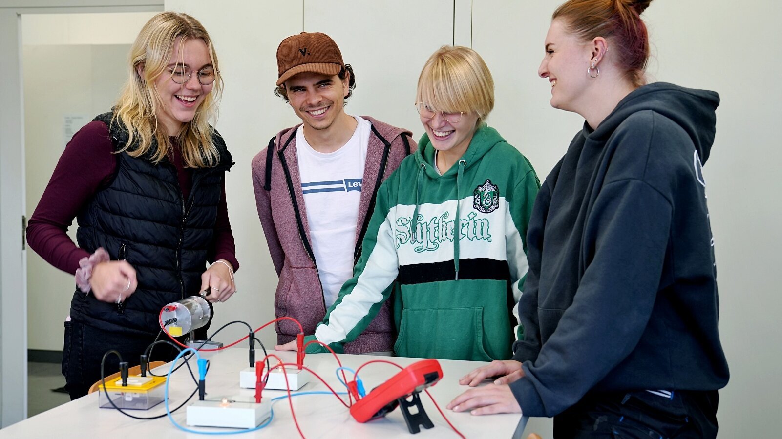 Studierende der Physik stehen vor einem Generator