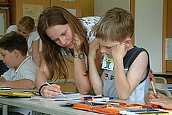 junge Frau, die einem Schüler etwas erklärt.