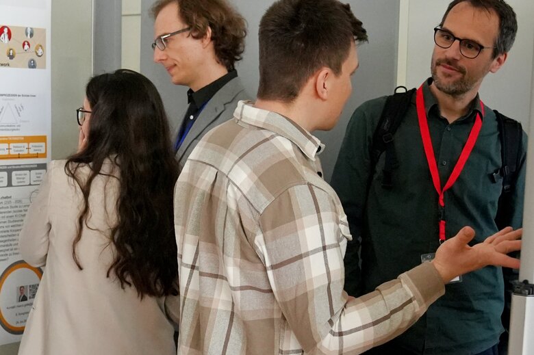 Mehrere Wissenschaflter:innen stehen vor einem Forschungsposter.