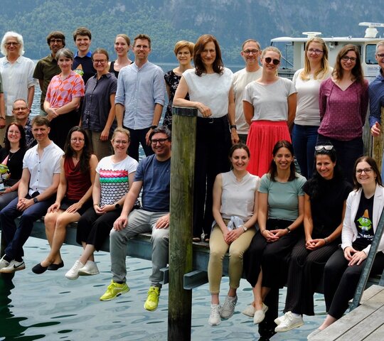 Das Foto zeigt die Teilnehmer und Teilnehmerinnen der Doktorierendentagung 2026 in einem Gruppenfoto am See.